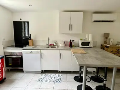 a kitchen with white cabinets and a counter top at Appartement Porto-Vecchio in Porto-Vecchio