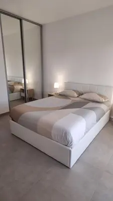 a large white bed in a bedroom with glassdoors at BELLE Demeure in Pietrosella