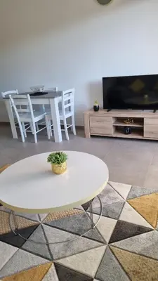a white coffee table in a living room with a tv at BELLE Demeure in Pietrosella