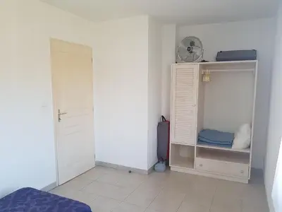 a bedroom with a white closet with a fan and a clock at Casa di u sole in Santa-Maria-Poggio