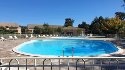 a large swimming pool with chairs and a fence at Casa di u sole in Santa-Maria-Poggio
