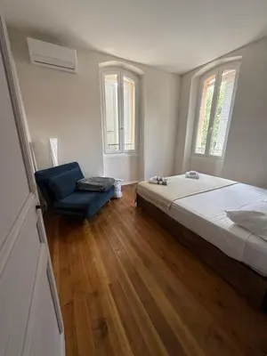 a bedroom with a bed and a blue chair at Villa Marcelle in Evisa