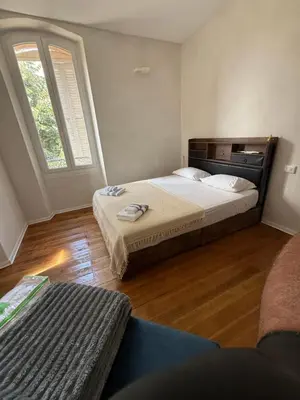 a bedroom with two beds and a large window at Villa Marcelle in Evisa