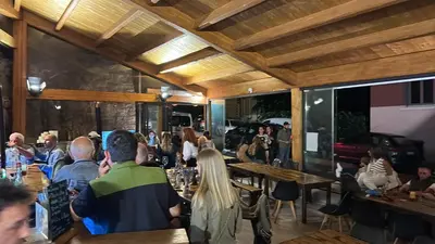a group of people sitting at tables in a restaurant at Villa Marcelle in Evisa