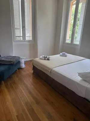a bedroom with a large bed and two windows at Villa Marcelle in Evisa