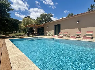 a swimming pool with chairs and a house at Villa neuve pinarello avec piscine privée, plage à 450m in Zonza