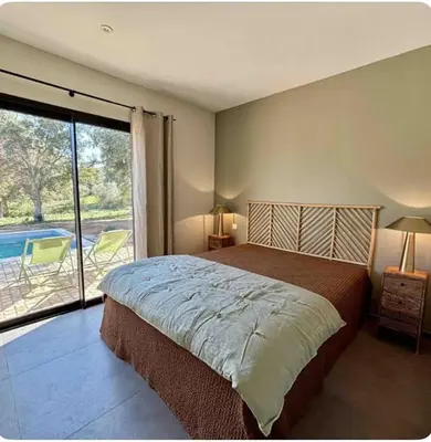 a bedroom with a bed and a view of a pool at Villa neuve pinarello avec piscine privée, plage à 450m in Zonza