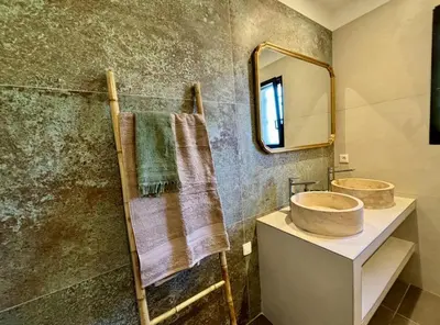 a bathroom with a sink and a mirror at Villa neuve pinarello avec piscine privée, plage à 450m in Zonza