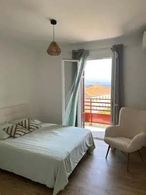 a bedroom with a bed and a chair and a window at Appartement F3 vue mer in Ajaccio