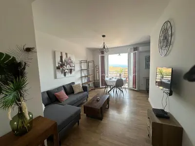 a living room with a couch and a table at Appartement F3 vue mer in Ajaccio