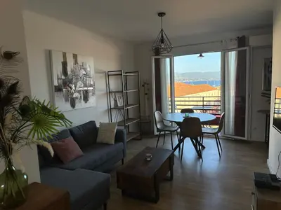 a living room with a couch and a table at Appartement F3 vue mer in Ajaccio