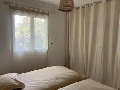 a bedroom with a bed and a window at Villa L et Villa J in Prunelli-di-Fiumorbo