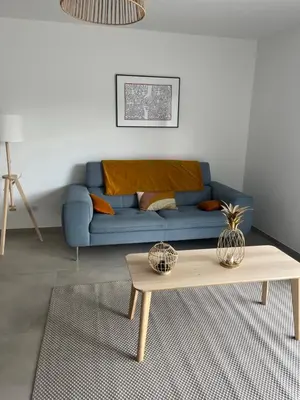 a living room with a blue couch and a coffee table at Villa L et Villa J in Prunelli-di-Fiumorbo