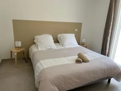 a bedroom with a large bed with white sheets and pillows at Villa L et Villa J in Prunelli-di-Fiumorbo