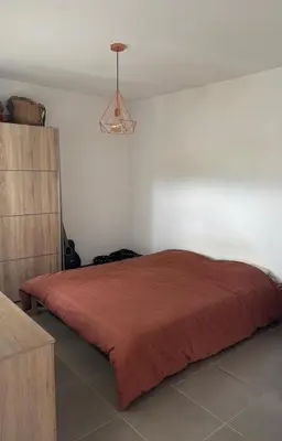 a bedroom with a bed with a red blanket at Location de vacances in Ghisonaccia