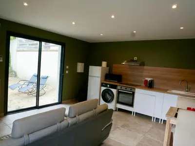 a living room with a couch and a kitchen at Casa Alta in Zonza
