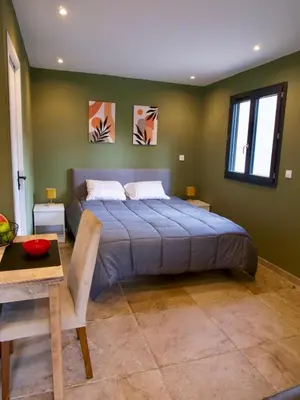 a bedroom with a large bed with green walls at Casa Alta in Zonza