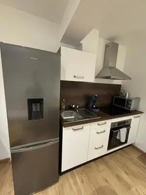 a small kitchen with a refrigerator and a sink at Appartement Ajaccio studio in Ajaccio
