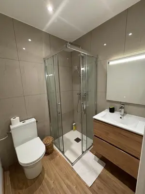 a living room with a flat screen tv and a table at Appartement Ajaccio studio in Ajaccio