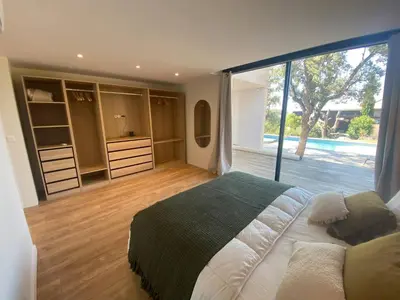 a bedroom with a large bed and a large window at Villa & Casa Sadrea in Lecci
