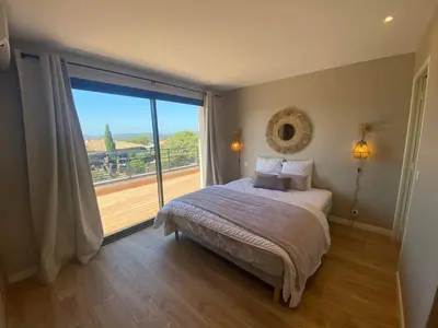 a bedroom with a bed and a large window at Villa & Casa Sadrea in Lecci