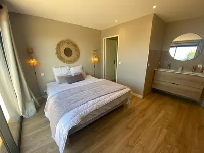 a bedroom with a bed and a bathroom with a tub at Villa & Casa Sadrea in Lecci