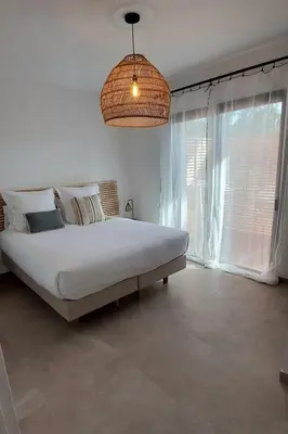 a bedroom with a large bed and a large window at résidence Terra Verde in Porto-Vecchio