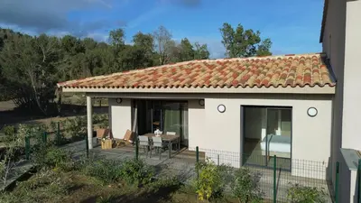 a small white house with a table and chairs at résidence Terra Verde in Porto-Vecchio