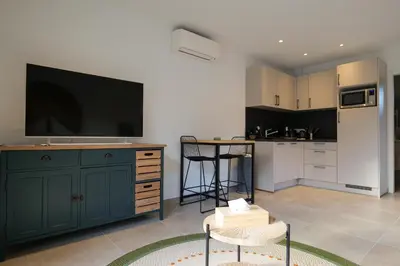 a kitchen with a large tv on the wall at résidence Terra Verde in Porto-Vecchio