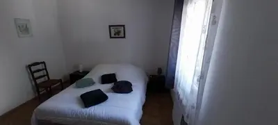 a small bedroom with a white bed and a window at Agréable bas de villa in Furiani