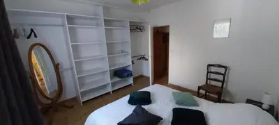 a bedroom with a white bed and a mirror at Agréable bas de villa in Furiani