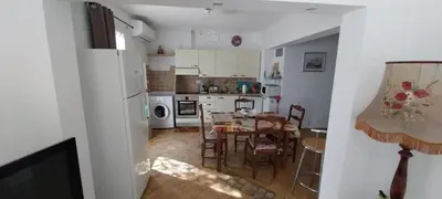 a kitchen with a table and a dining room at Agréable bas de villa in Furiani