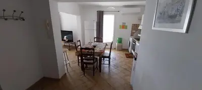 a kitchen and dining room with a table and chairs at Agréable bas de villa in Furiani