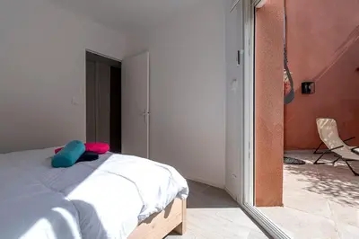 a bedroom with a bed and a room with a chair at Canelli - Magnifique Vue Mer in Pietrosella