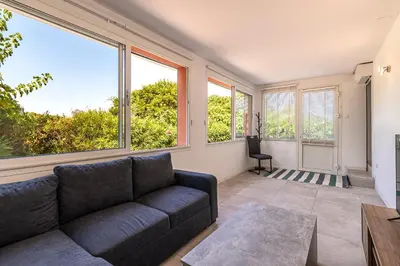 a living room with a couch and large windows at Canelli - Magnifique Vue Mer in Pietrosella