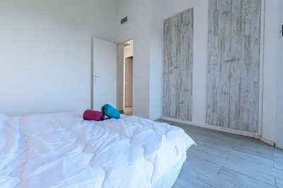 a bedroom with a large white bed with two bags on it at Canelli - Magnifique Vue Mer in Pietrosella