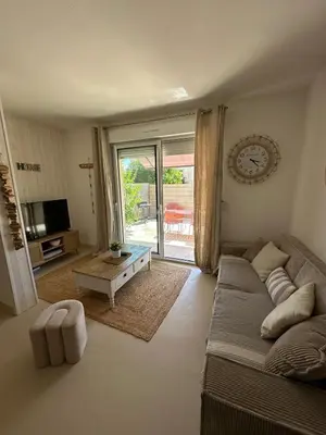 a living room with a couch and a tv at La Villa des Sables Borgu in Borgo