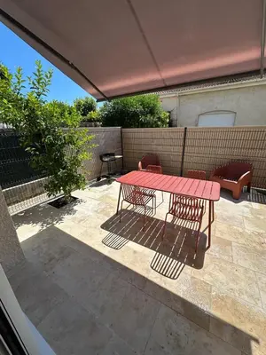 a red table and chairs on a patio at La Villa des Sables Borgu in Borgo