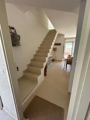 a staircase in a living room with a stair case at La Villa des Sables Borgu in Borgo