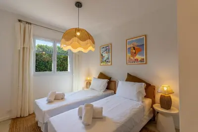 two twin beds in a bedroom with a chandelier at Villa Rossa in Lecci