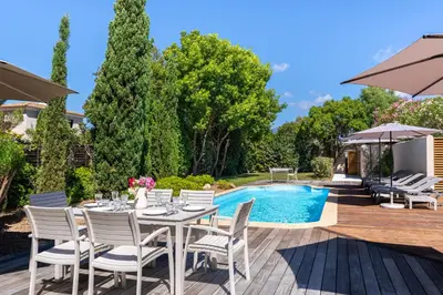 a patio with a table and chairs next to a pool at Villa Rossa in Lecci