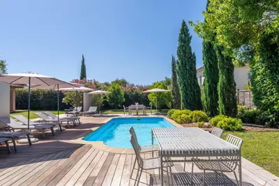 a patio with tables and chairs and a swimming pool at Villa Rossa in Lecci