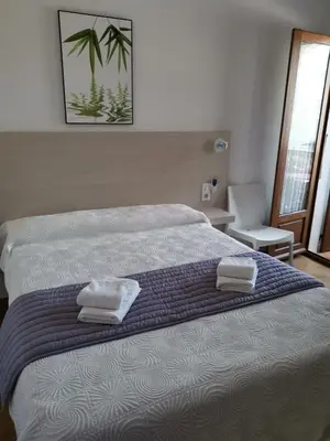 a bedroom with a bed with two towels on it at Hôtel Punta e Mare des Chambres ou des Appartements T2 in Cargèse