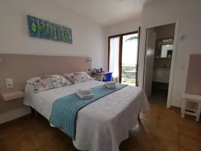 a bedroom with a bed with two towels on it at Hôtel Punta e Mare des Chambres ou des Appartements T2 in Cargèse