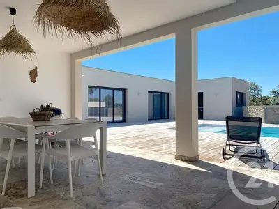 a white dining room with a table and a chair at Villa de standing, proche des plages et au calme in Lecci