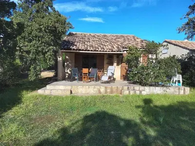 a house with a patio and chairs in the yard at Villa Surleau in Zonza