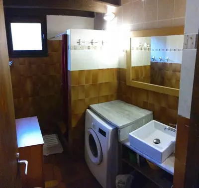 a bathroom with a washing machine and a sink at Villa Surleau in Zonza