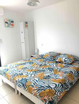 a bed with a colorful comforter in a bedroom at propriano pieds dans l eau in Propriano