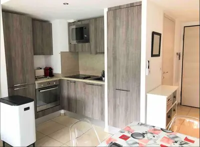 a kitchen with wooden cabinets and a table in it at propriano pieds dans l eau in Propriano