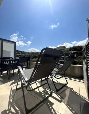 a pair of chairs sitting on top of a balcony at propriano pieds dans l eau in Propriano